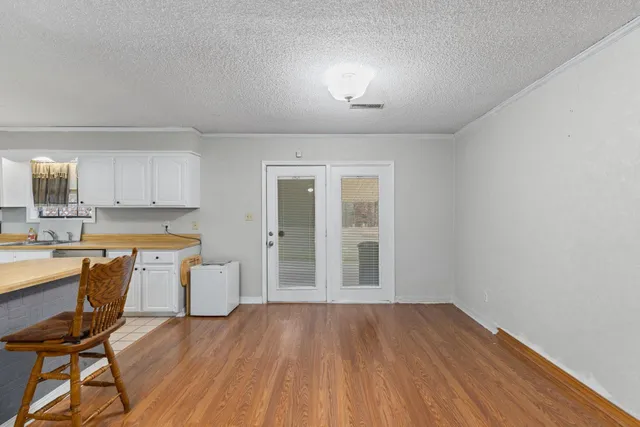 a view of a kitchen with wooden floor and a window