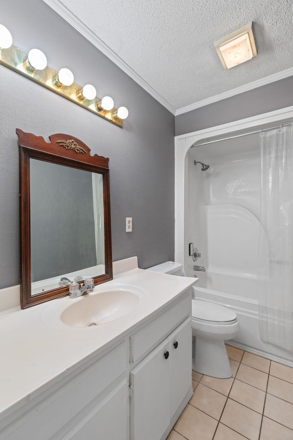 310 County Road 638 Corinth, MS 38834 - Photo 10 of 40 Full bath featuring shower / bath combo, a textured ceiling, vanity, light tile patterned floors, and ornamental molding
