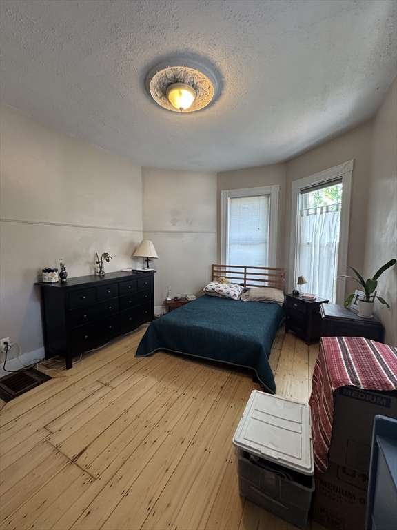 5 Spring Park Avenue, Unit 1 Boston, MA 02130 - Photo 13 of 24 a bedroom with a bed and a night stand