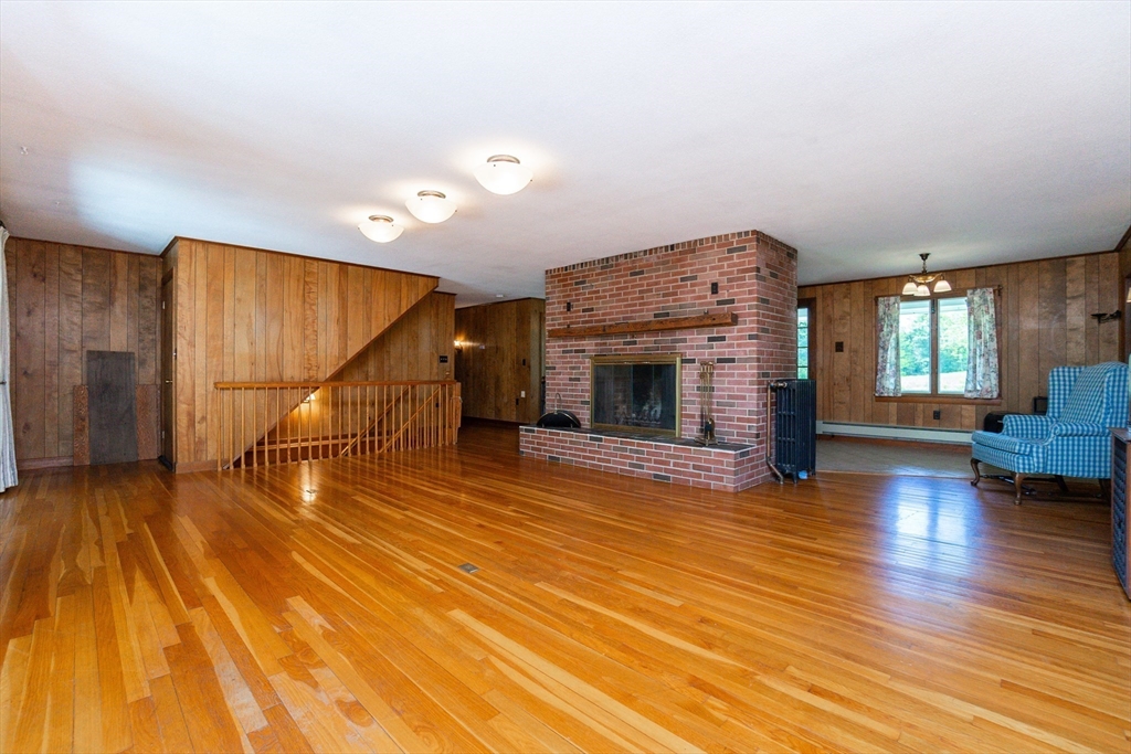 152 Stowell Road Ashburnham, MA 01430 - Photo 3 of 38 a view of empty room with wooden floor and fireplace