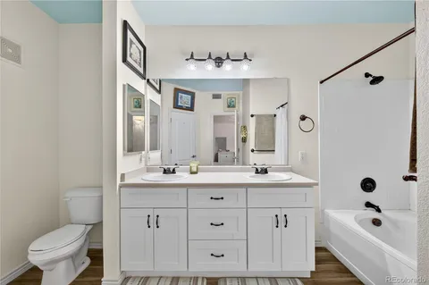 a bathroom with a double vanity sink and mirror with shower