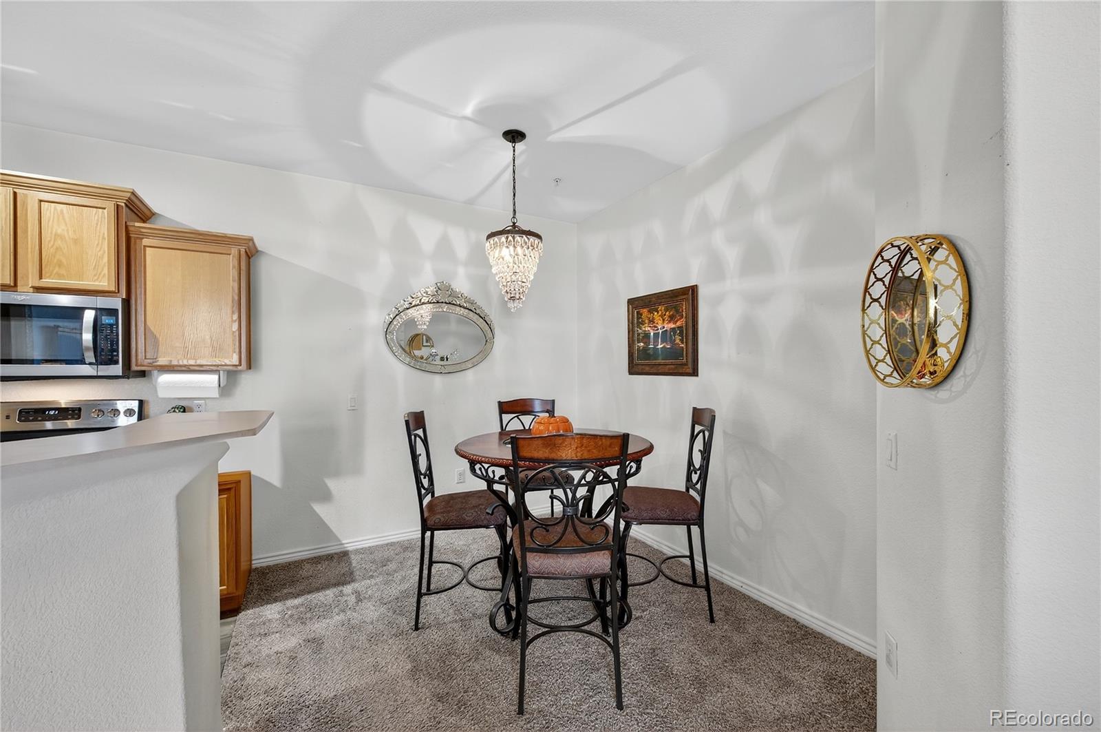 18611 Stroh Road, Unit 5203 Parker, CO 80134 - Photo 6 of 28 a view of a dining room with furniture and a chandelier