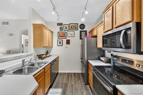 a kitchen with stainless steel appliances a stove a sink dishwasher a refrigerator and a stove