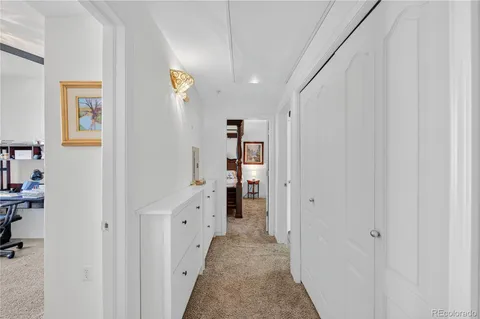 a view of a hallway with wooden shelves
