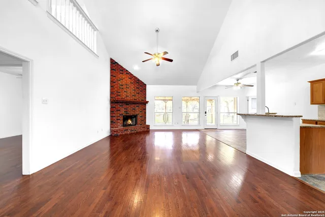 a view of empty room with wooden floor and fireplace