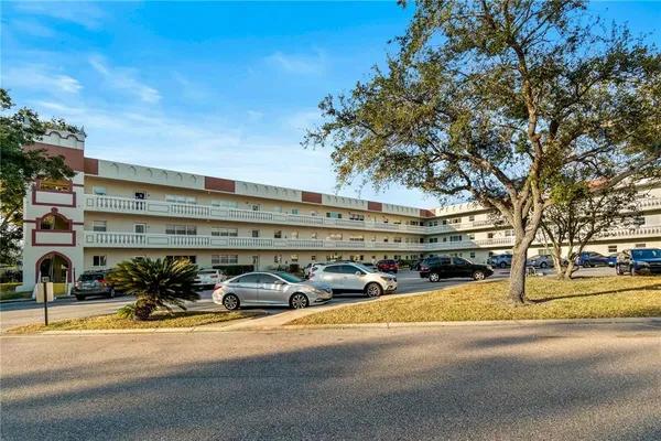 a view of a building with cars parked