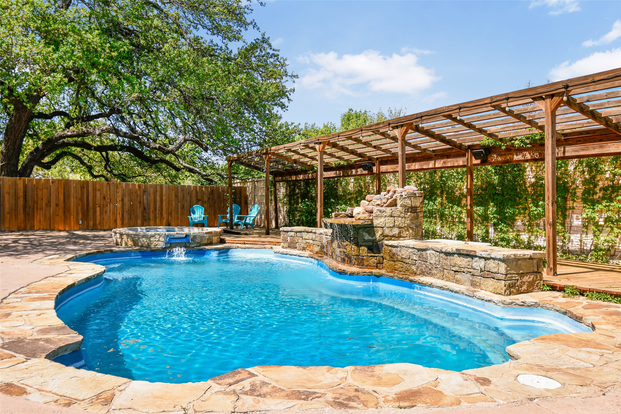 Relaxing pool / spa with a pergola, a fenced backyard, and a patio area