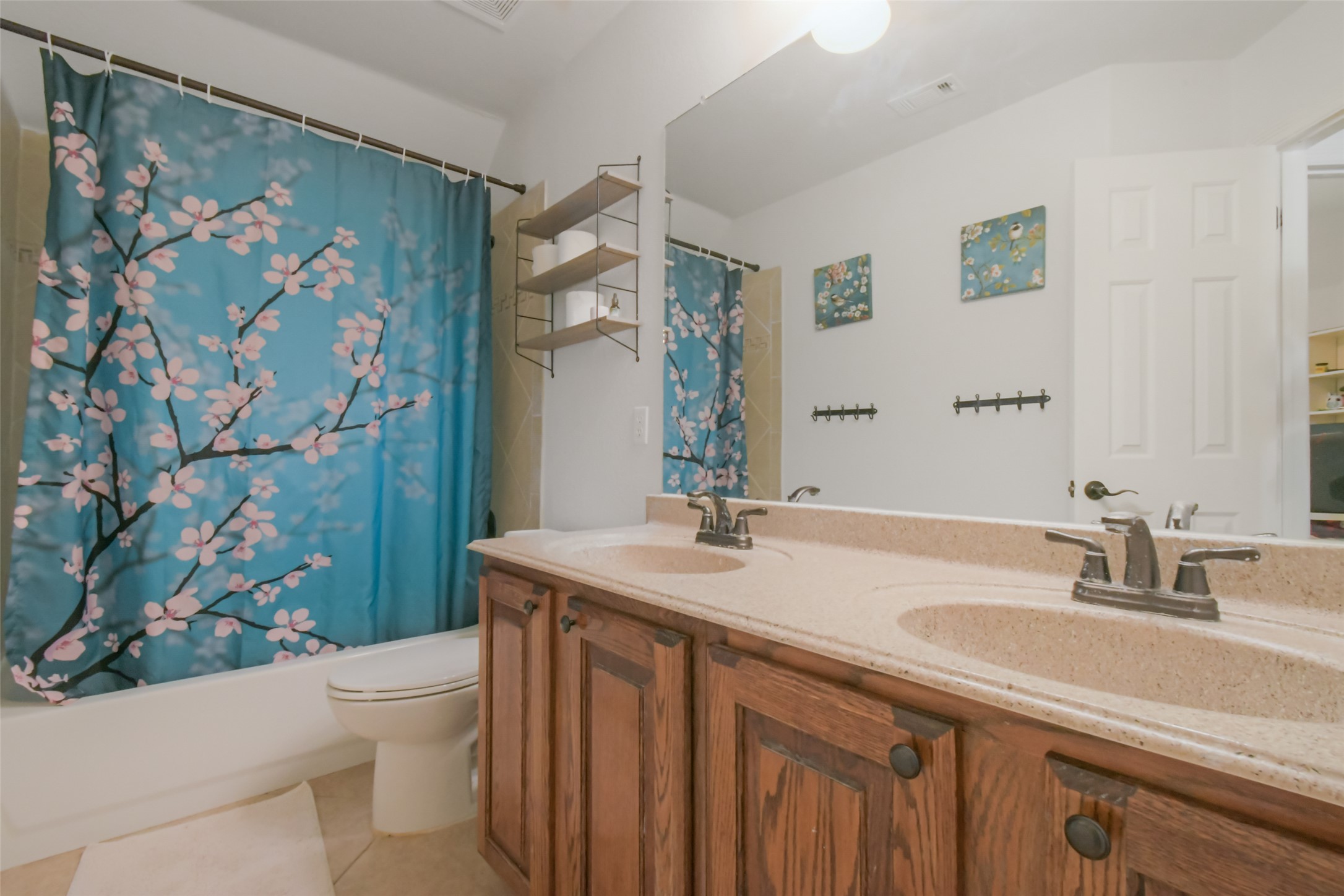 8903 Halder Cove Austin, TX 78717 - Photo 13 of 26 Bathroom with double vanity, shower / bathtub combination with curtain, and light tile patterned floors
