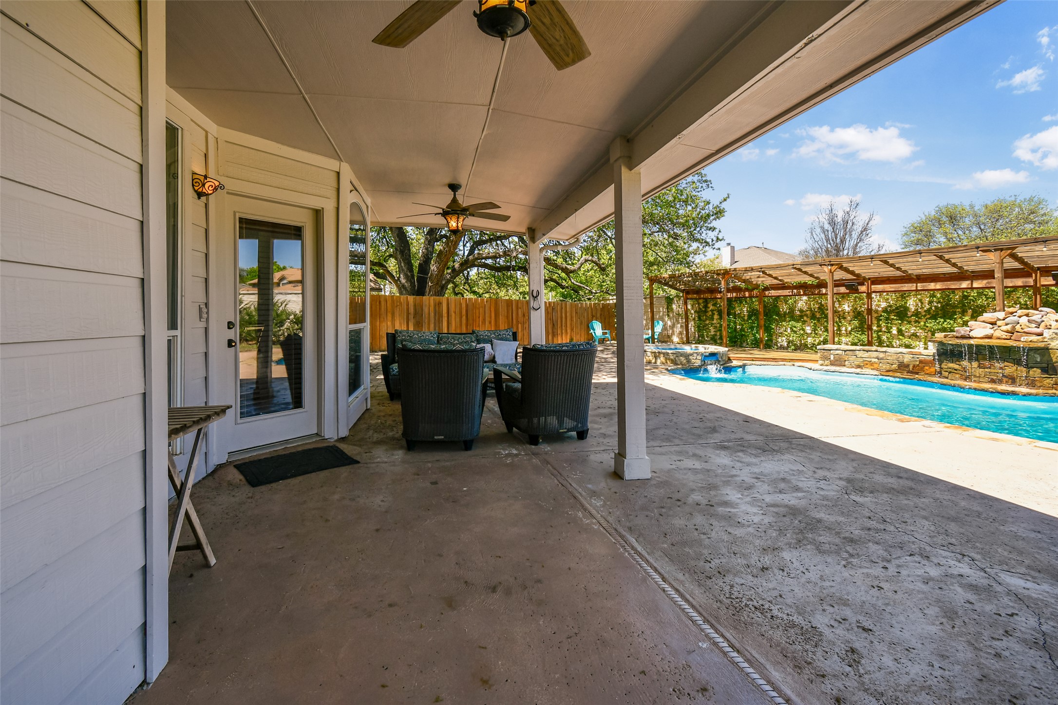 8903 Halder Cove Austin, TX 78717 - Photo 22 of 26 Fenced backyard featuring a patio, a ceiling fan, outdoor dining area, a pergola, and a pool with connected hot tub
