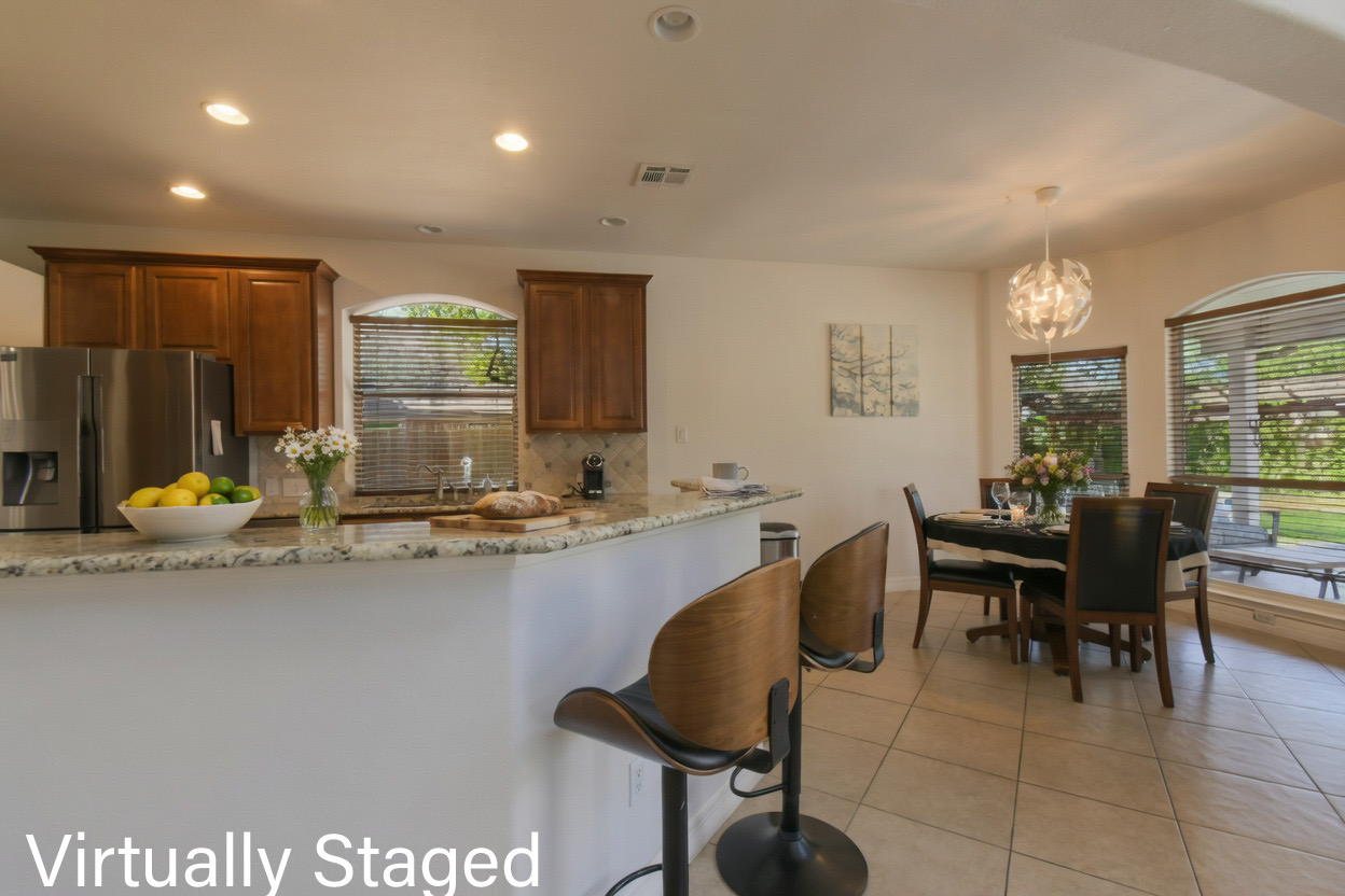 8903 Halder Cove Austin, TX 78717 - Photo 8 of 26 Kitchen with stainless steel fridge, granite stone countertops, light tile patterned floors, a breakfast bar, and decorative backsplash