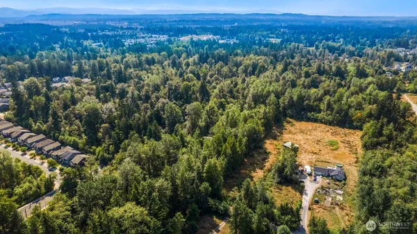 an aerial view of a residential houses covered in trees
