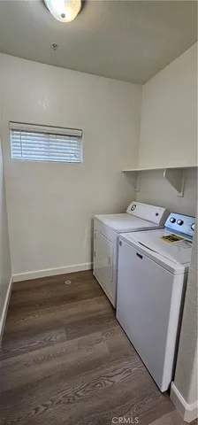 a storage room with wooden floor washer and dryer