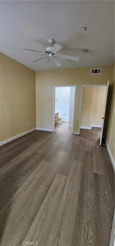 a view of a hallway with a chandelier fan and wooden floor