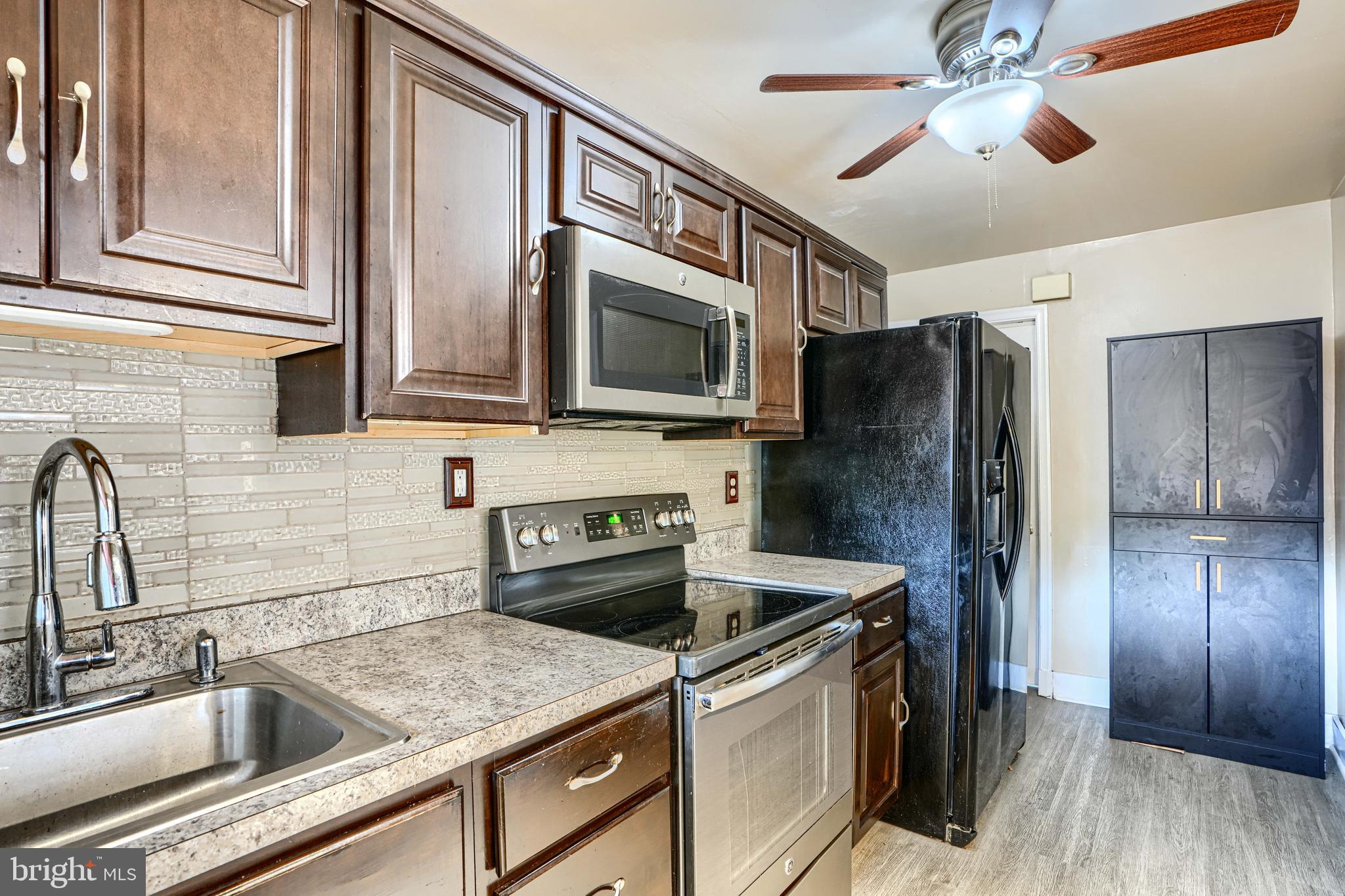 755 South Woodington Road Baltimore, MD 21229 - Photo 13 of 40 a kitchen with stainless steel appliances granite countertop a refrigerator and a sink