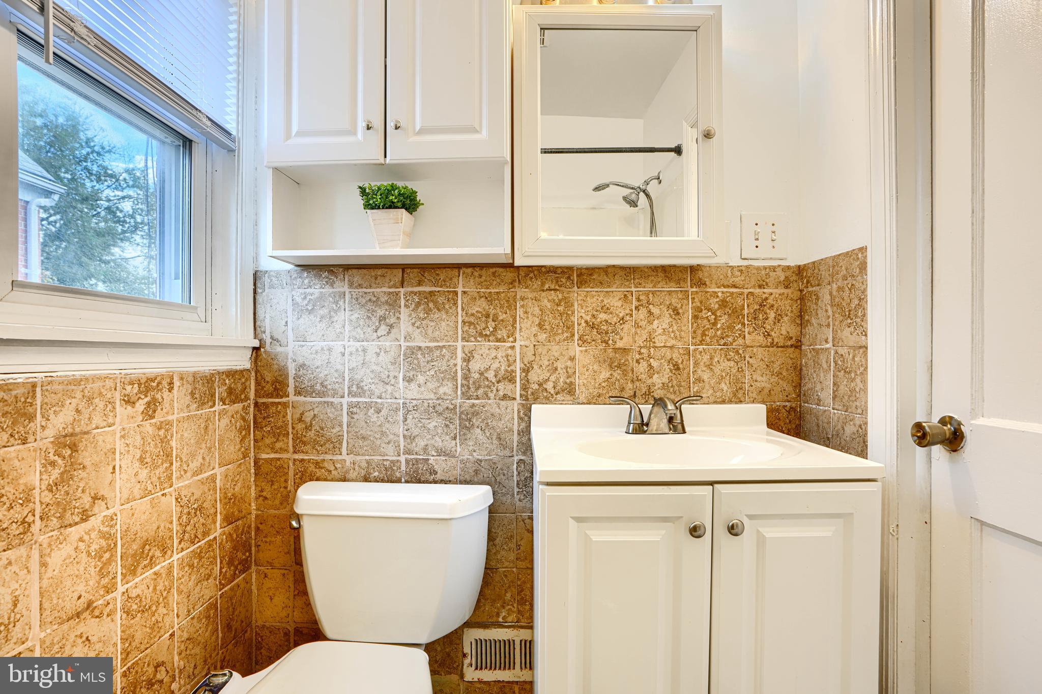 755 South Woodington Road Baltimore, MD 21229 - Photo 26 of 40 a bathroom with a sink mirror and toilet