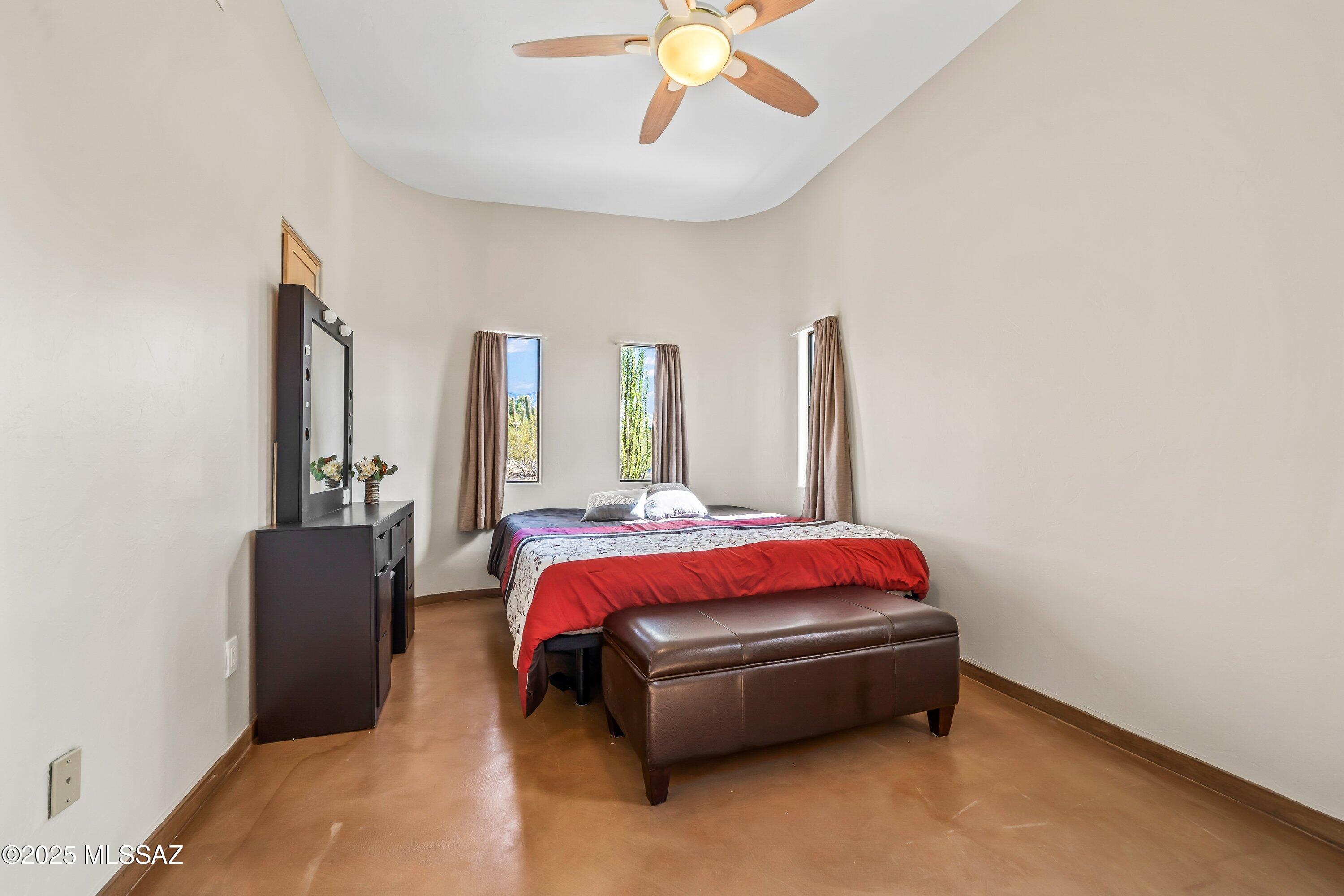 30 West Stone Loop Tucson, AZ 85704 - Photo 12 of 26 a spacious bedroom with a bed and a chandelier