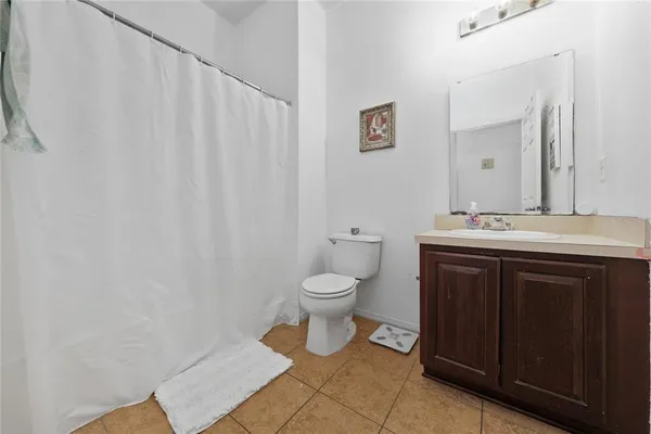 a bedroom with a bed and a flat tv screen on dresser