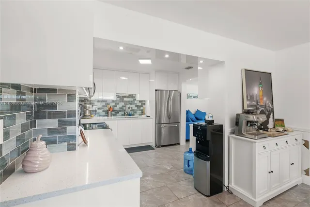 a kitchen with refrigerator and cabinets