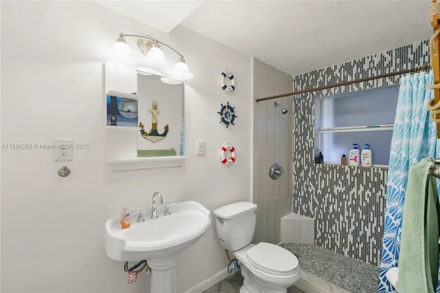 a bathroom with a sink toilet and shower