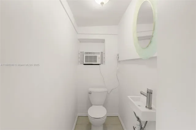 a white toilet sitting next to a bathroom sink