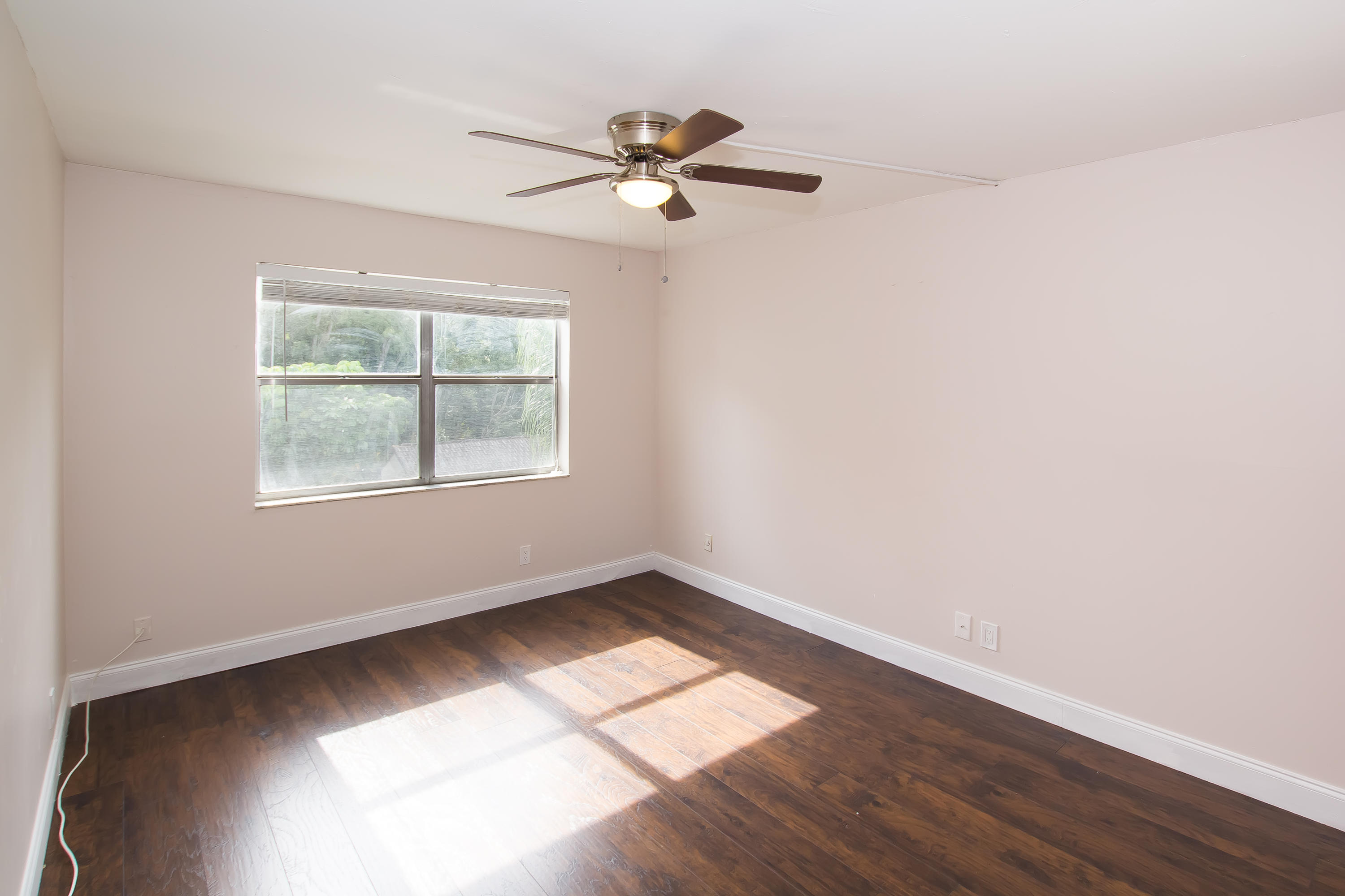 7080 Nova Drive, Unit 306B Davie, FL 33317 - Photo 23 of 25 an empty room with wooden floor chandelier fan and windows