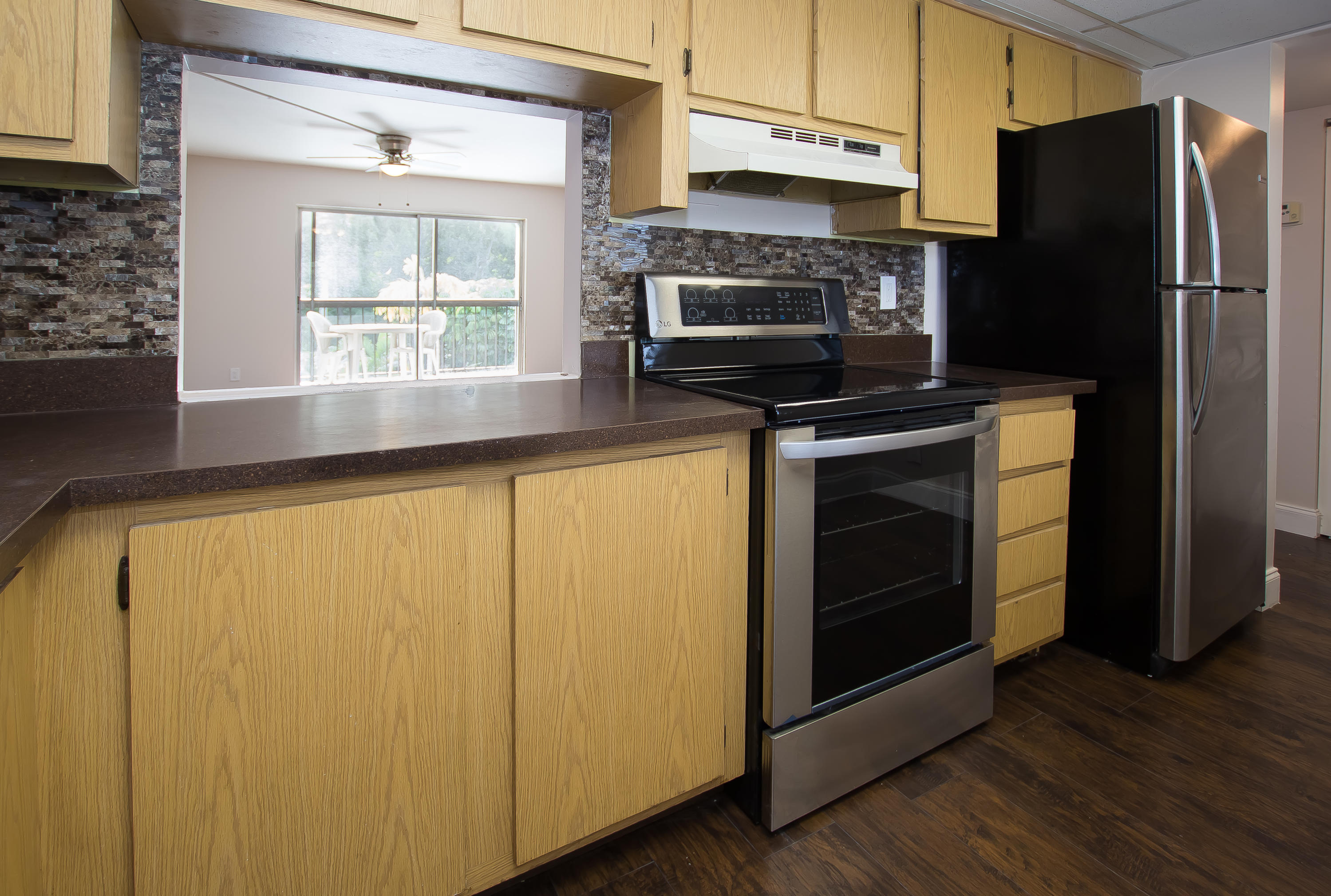 7080 Nova Drive, Unit 306B Davie, FL 33317 - Photo 8 of 25 a kitchen with granite countertop a refrigerator stove and microwave