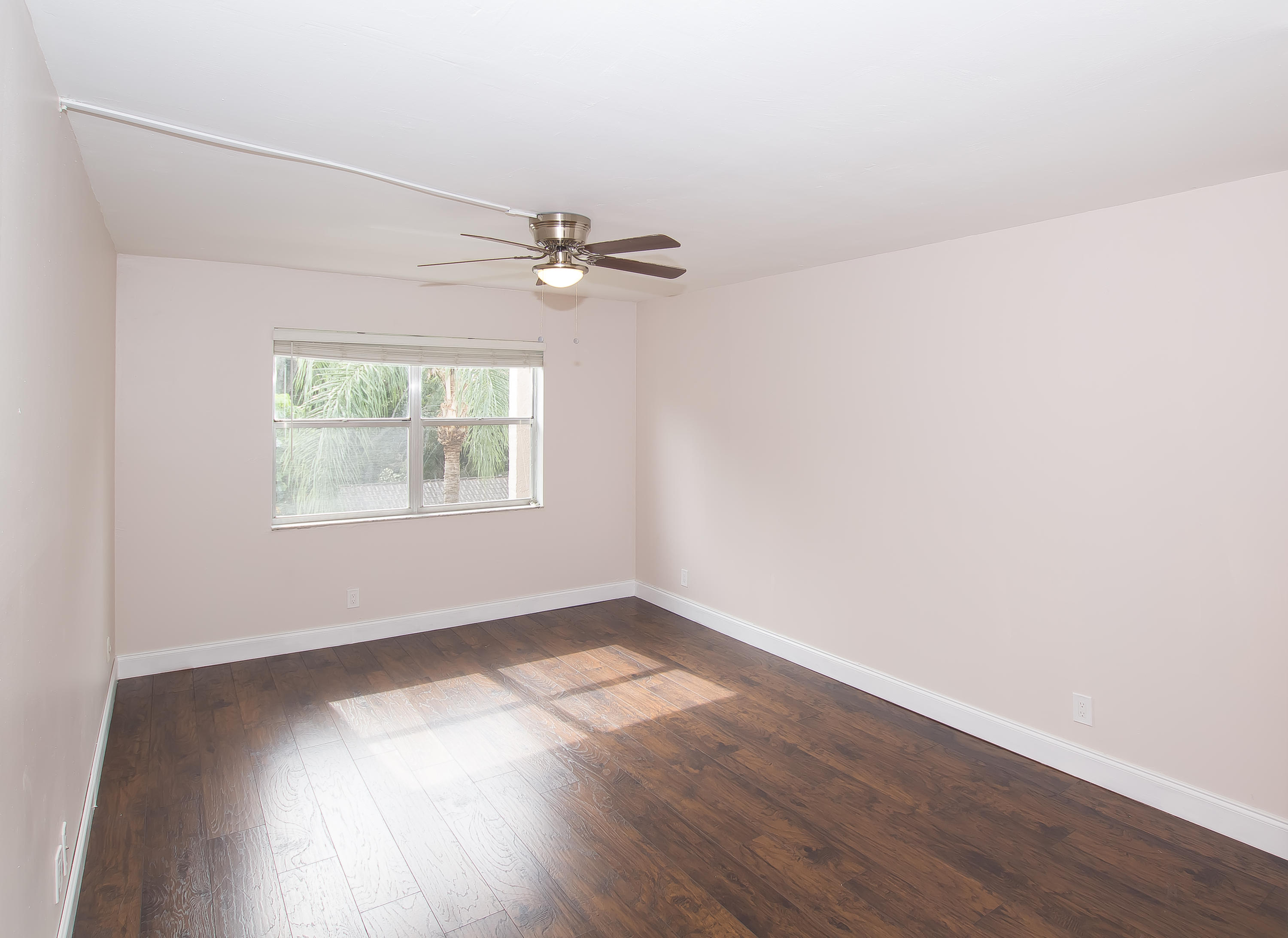7080 Nova Drive, Unit 306B Davie, FL 33317 - Photo 10 of 25 an empty room with wooden floor chandelier fan and windows