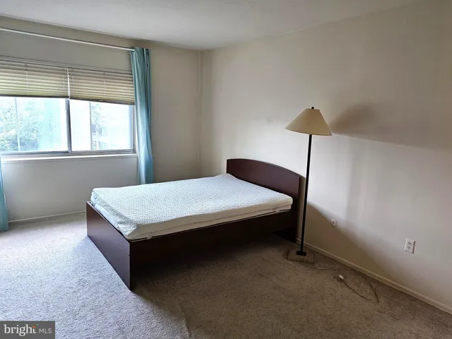 a bed sitting in a bedroom next to a window