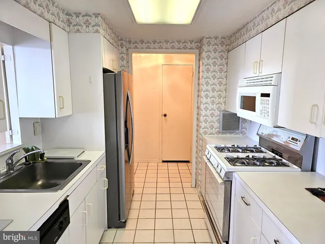 a kitchen that has a sink stainless steel appliances a counter space and a window