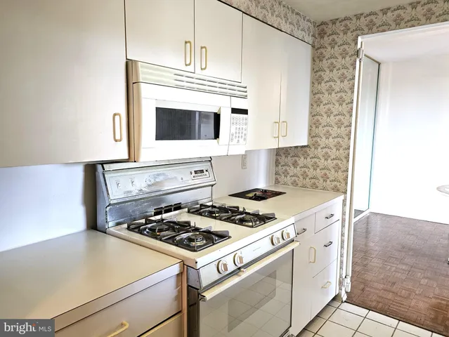 a white stove top oven sitting inside of a kitchen