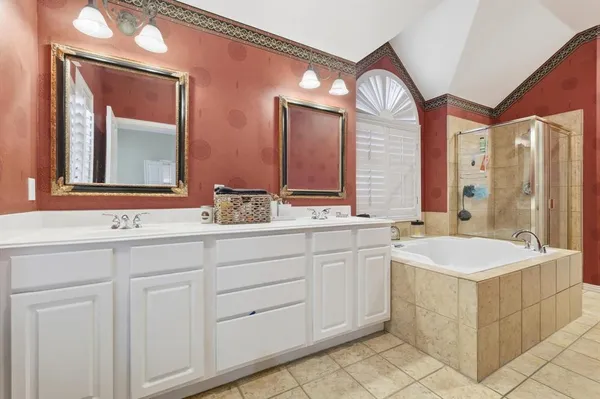 a bathroom with a double vanity sink mirror and bathtub