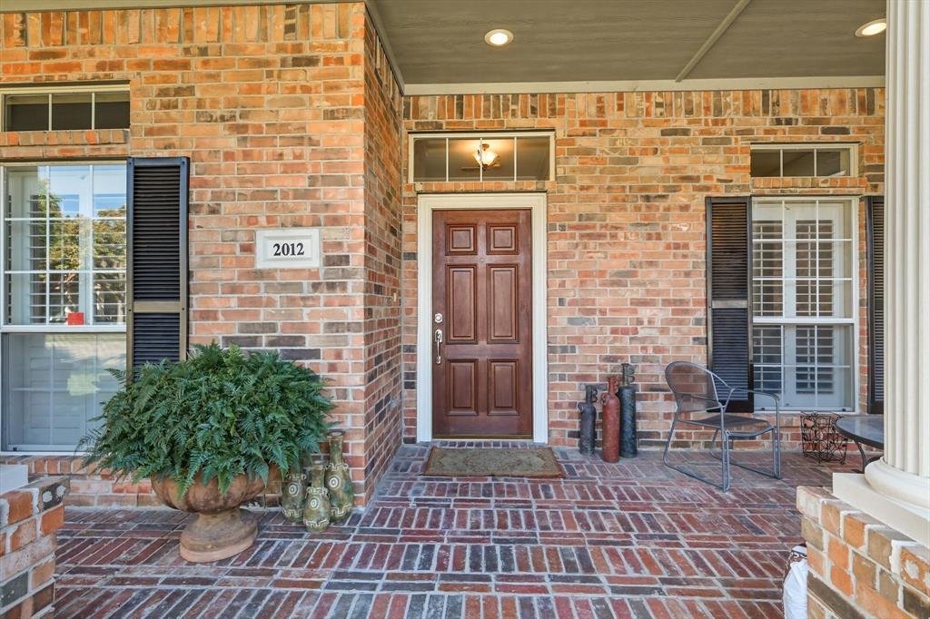 2012 Hayden Lane Corinth, TX 76210 - Photo 3 of 40 a brick building with a bench in front of door