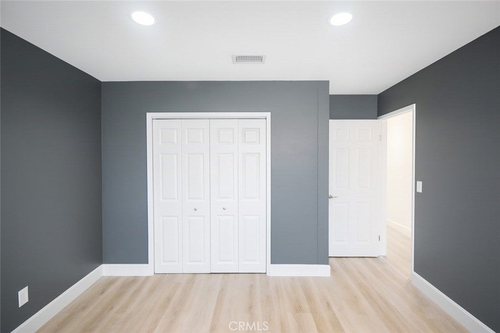 5114 West 1st Street, Unit C Santa Ana, CA 92703 - Photo 12 of 26 an empty room with wooden floor and windows