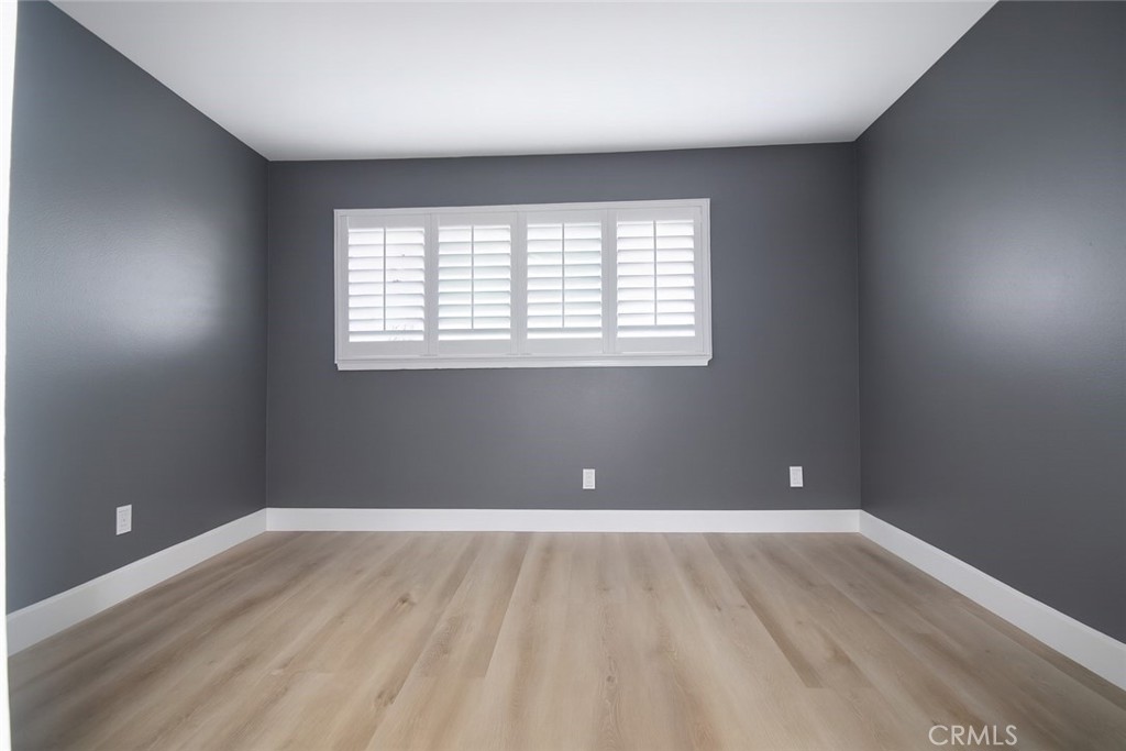 5114 West 1st Street, Unit C Santa Ana, CA 92703 - Photo 13 of 26 an empty room with wooden floor and windows