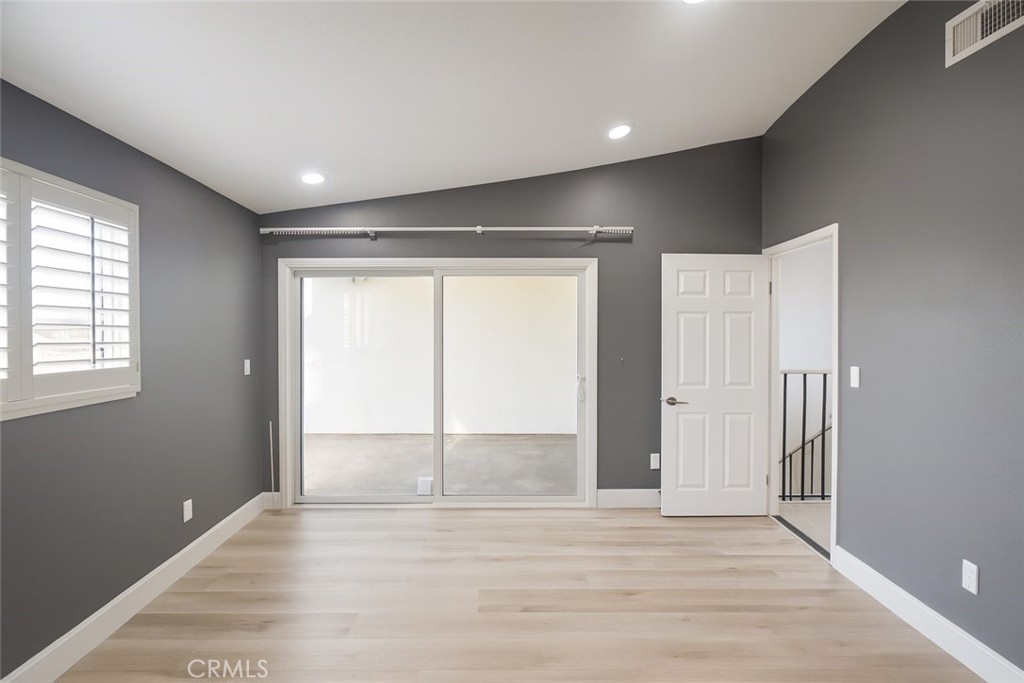 5114 West 1st Street, Unit C Santa Ana, CA 92703 - Photo 17 of 26 an empty room with wooden floor and windows