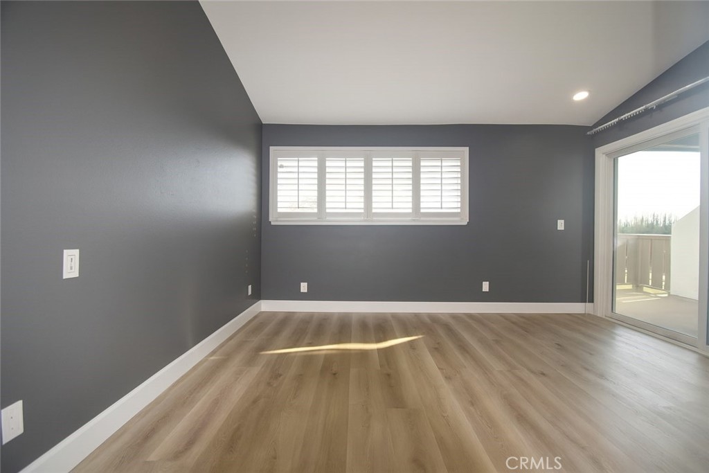 5114 West 1st Street, Unit C Santa Ana, CA 92703 - Photo 18 of 26 an empty room with wooden floor and windows