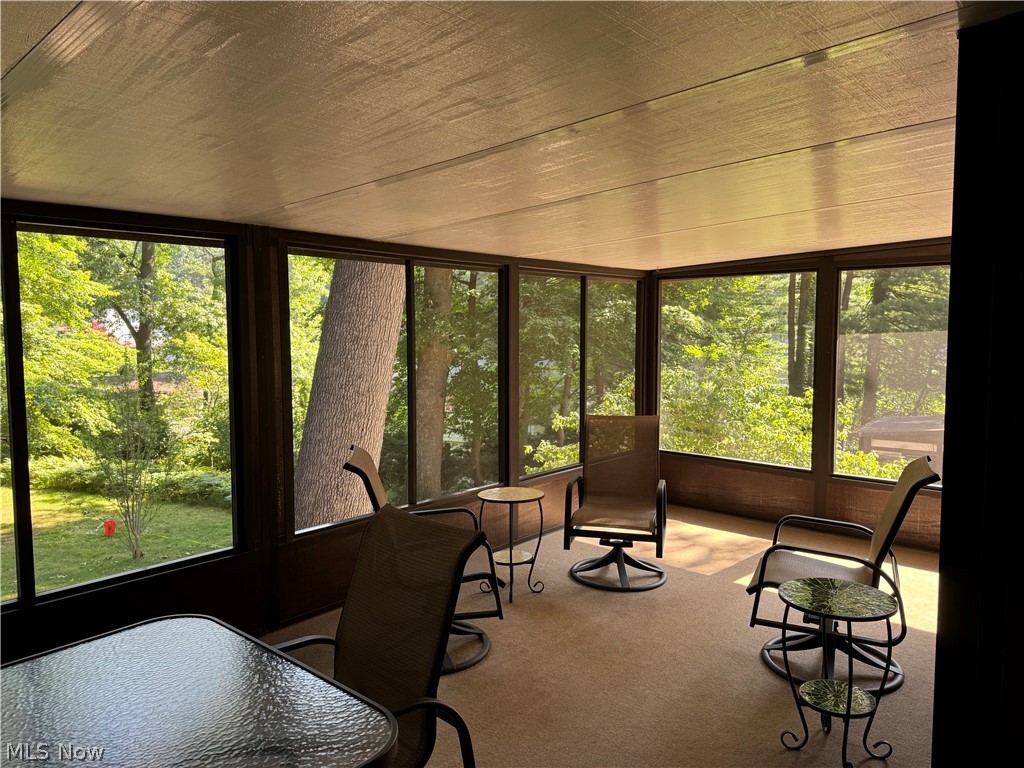 205 Rutledge Drive Akron, OH 44319 - Photo 5 of 8 Screened-in porch featuring a full perimeter of windows, textured ceiling, and carpeted flooring