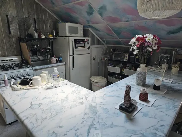 a kitchen with stainless steel appliances kitchen island granite countertop a sink stove and cabinets