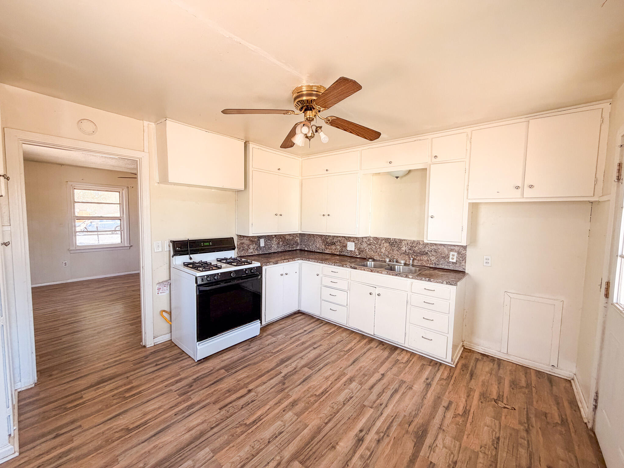 3207 Amherst Street Lubbock, TX 79415 - Photo 5 of 16 a kitchen with granite countertop wooden floors and white appliances