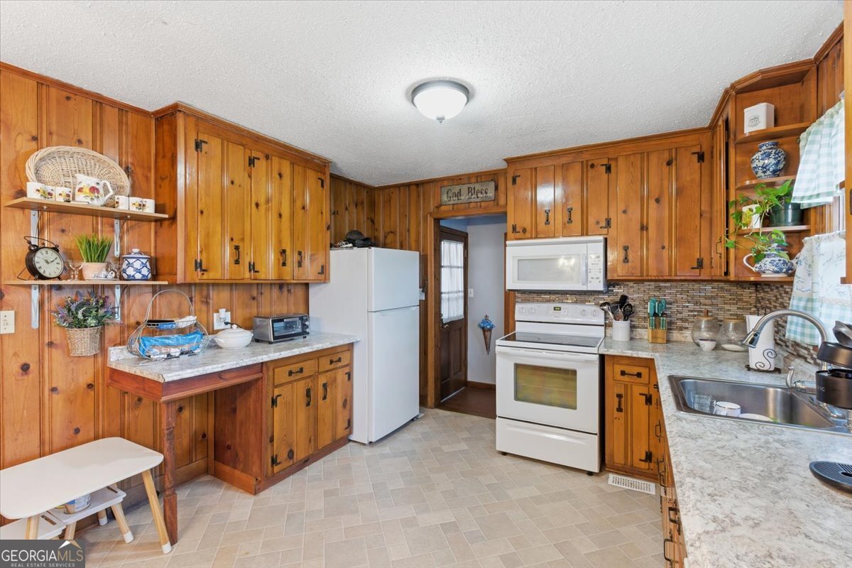 129 George West Road Cedartown, GA 30125 - Photo 15 of 36 a kitchen with a stove a refrigerator and wooden cabinets