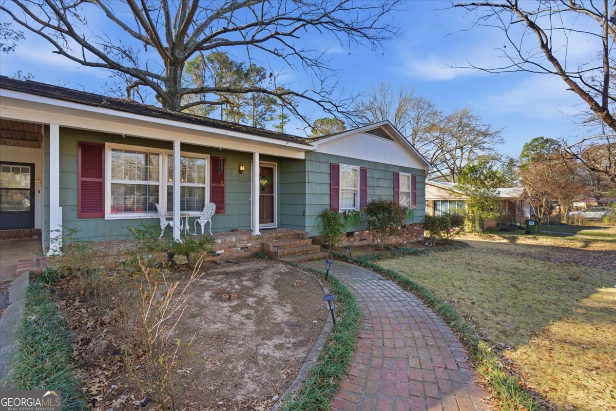 129 George West Road Cedartown, GA 30125 - Photo 5 of 36 a view of a brick house with large windows and a small yard