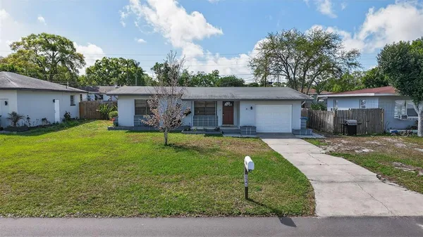 a view of a house with a yard patio and a small yard