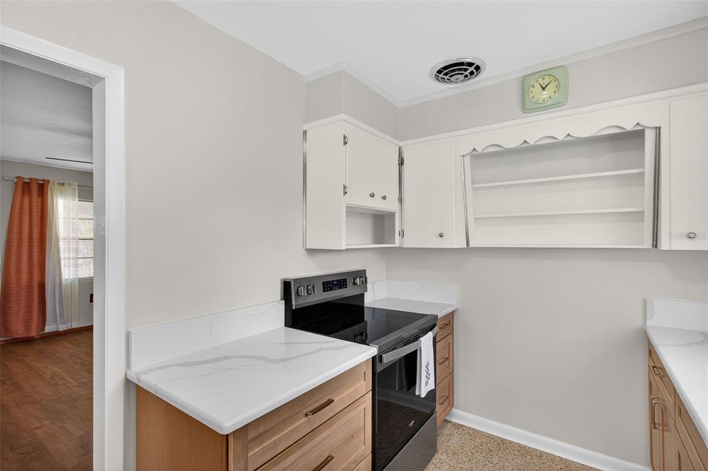 1541 Illinois Road Clearwater, FL 33756 - Photo 20 of 44 a kitchen with a stove cabinets and wooden floor