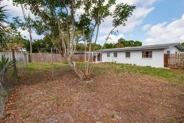 a front view of house with yard and trees around
