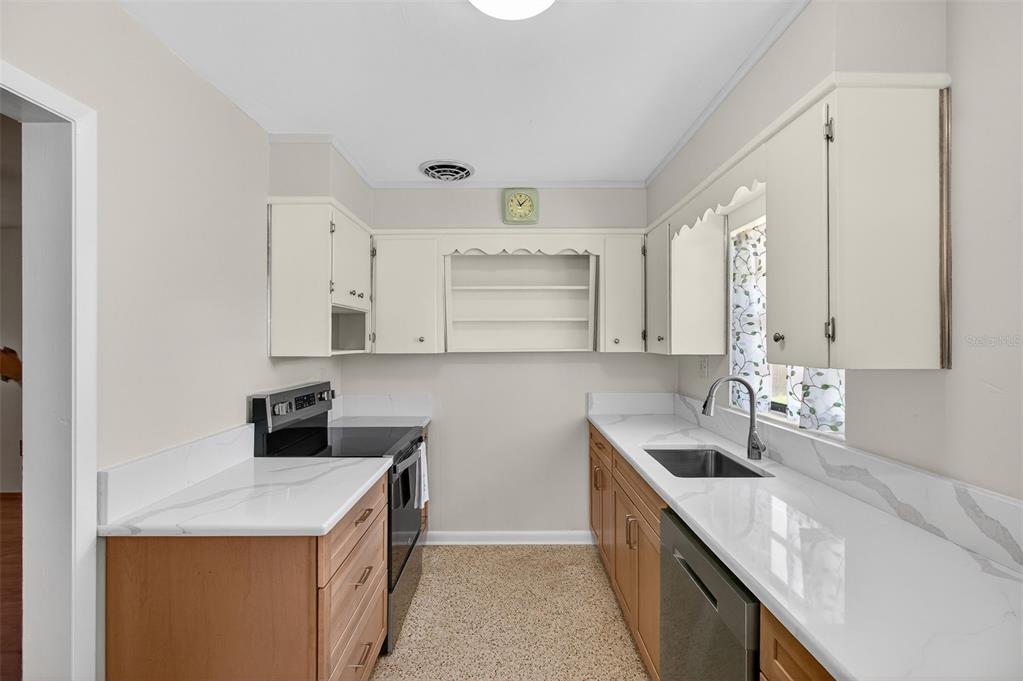 1541 Illinois Road Clearwater, FL 33756 - Photo 7 of 44 a kitchen with a sink a stove and cabinets