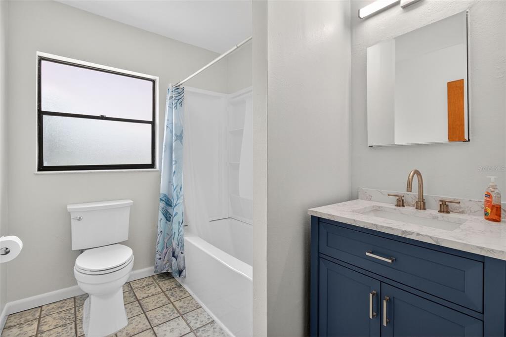 1541 Illinois Road Clearwater, FL 33756 - Photo 10 of 44 a bathroom with a toilet a sink and mirror