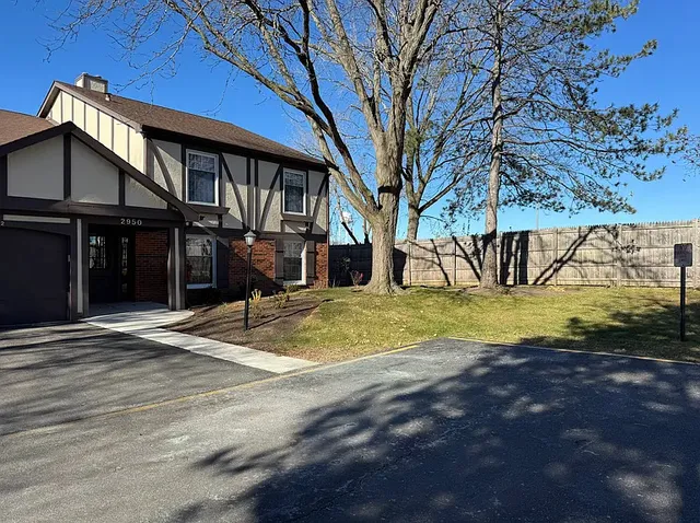 a view of a house with backyard and a tree
