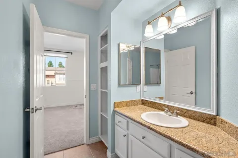 a bathroom with a granite countertop sink and a mirror