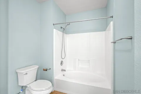 a white toilet sitting next to a bath tub shower