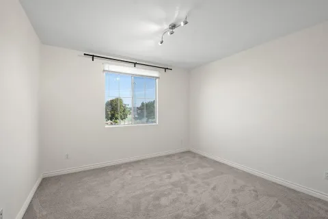 an empty room with a window and a ceiling fan